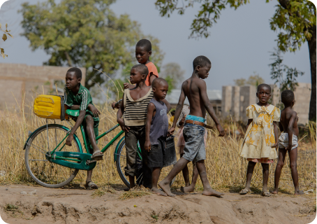 Children playing outside with adults in a village