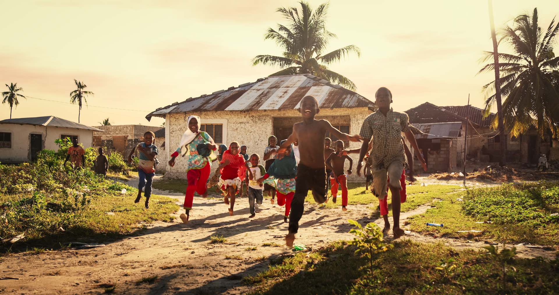 Children playing outside with adults in a village